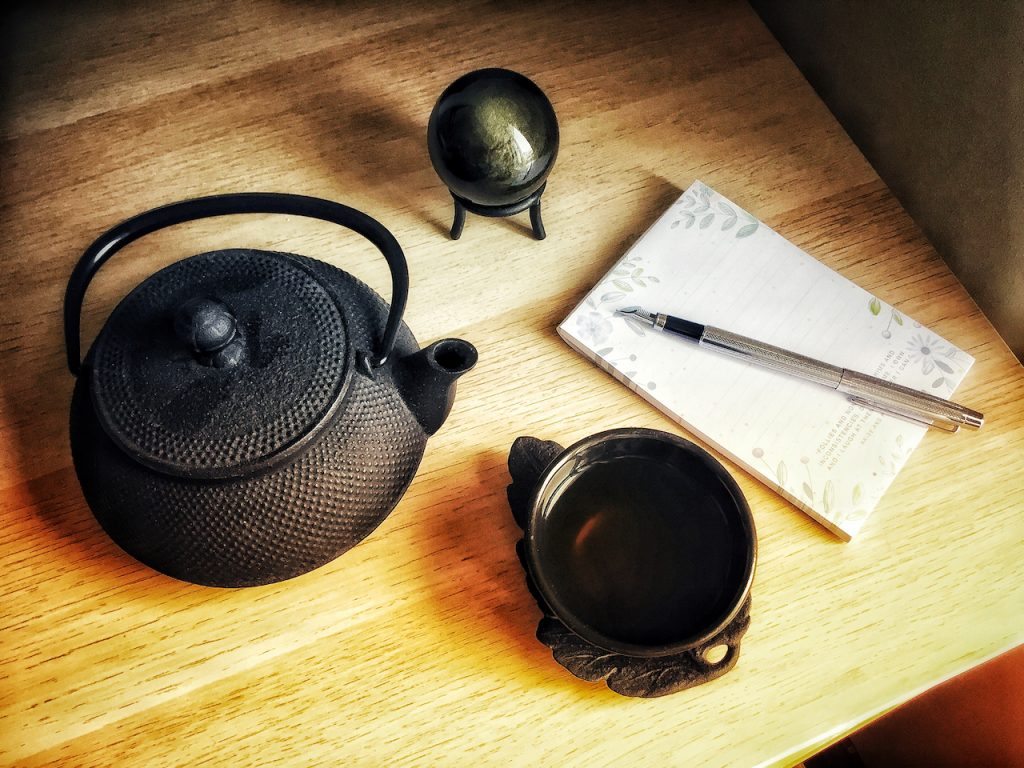 Photograph of an iron teapot and notebook