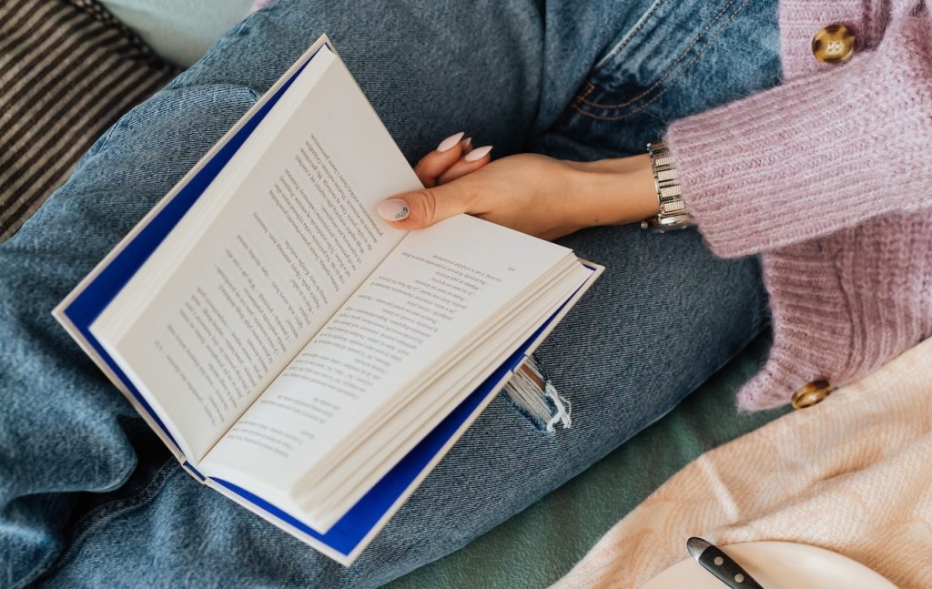 A close up of a woman with a book in her lap.