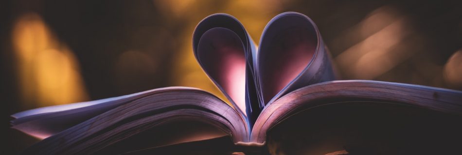 An open book with two pages curled to look like a heart
