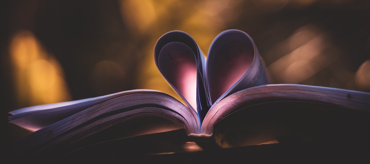 An open book with two pages curled to look like a heart