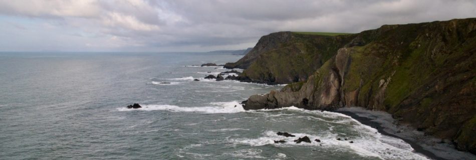 View looking across a Cornish coastline with an overcast sky.
