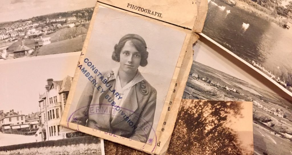 An old photograph of a young Helen Edith Toull surrounded by old postcards