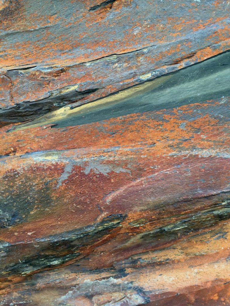 A photograph of the abstract colours and patterns running through the Cornish rock.