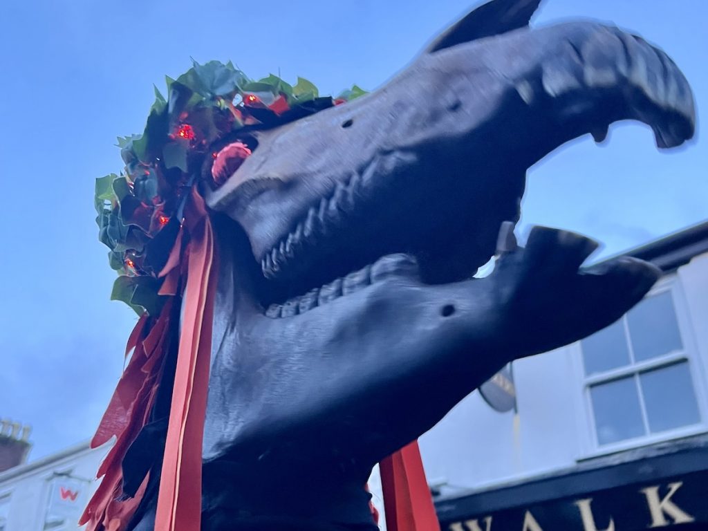 A photo from the Montol mid-winter festival in Penzance, Cornwall, depicting a "hobby horse" - a horse skull dressed in orange and black ribbons.