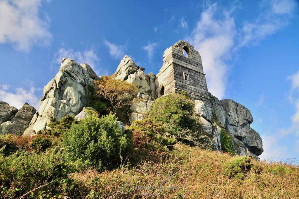 A granite eruption from the ground with the remains of a ruined church.