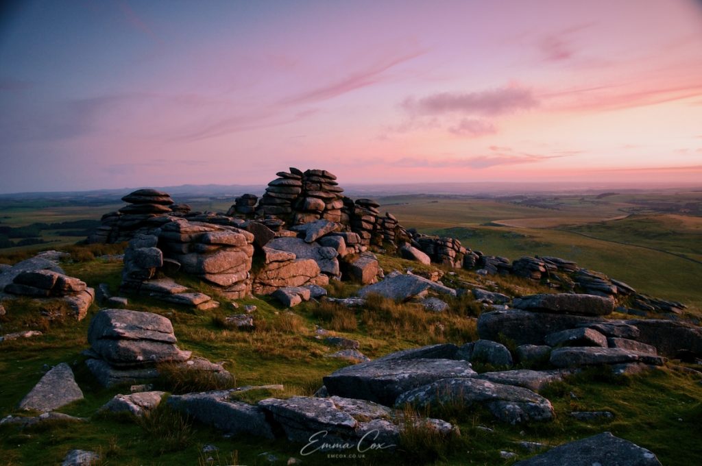 A photograph of Rough Tor, a granite-cropped hill, at sunset, on Bodmin Moor.