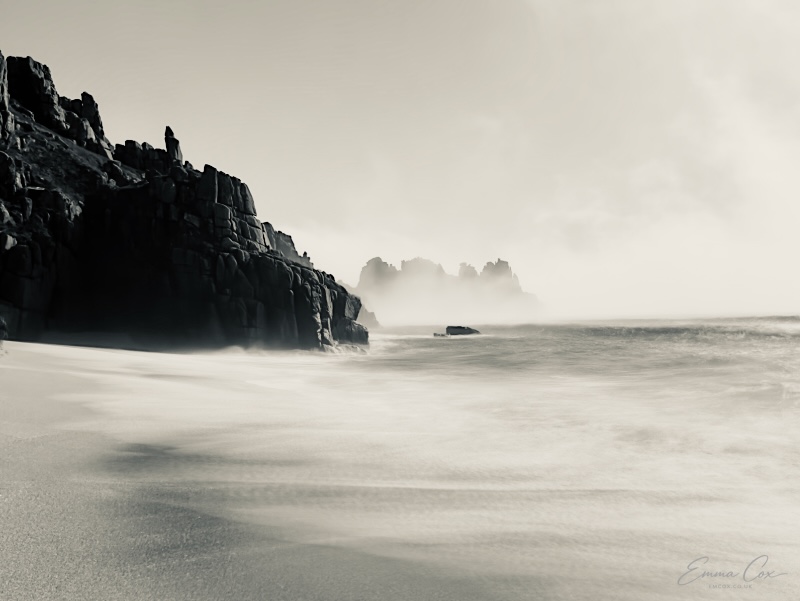 a distant headland surrounded by sea mist